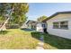 Spacious backyard with a stone path leading to a patio and lush green lawn at 14261 113Th Ave, Largo, FL 33774