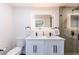 Modern bathroom featuring double sinks, illuminated mirror, and a glass-enclosed shower at 14261 113Th Ave, Largo, FL 33774