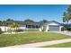 Charming single-story home featuring a brick facade, well-manicured lawn, and a two-car garage at 14261 113Th Ave, Largo, FL 33774