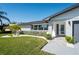 Close up of the attractive front exterior with a well kept lawn, white brick, and a modern front door at 14261 113Th Ave, Largo, FL 33774
