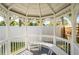 Inside a cozy white gazebo, featuring built-in seating and views of the green surroundings at 14261 113Th Ave, Largo, FL 33774