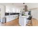 Open-concept kitchen with white cabinets, stainless steel appliances, a center island with bar stool seating at 14261 113Th Ave, Largo, FL 33774