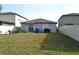 Backyard with a sliding glass door, patio, lush grass, and partial fence, providing privacy at 16725 Delia St, Wimauma, FL 33598