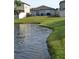 Backyard view with a lake, surrounded by well-maintained grass and fencing at 16725 Delia St, Wimauma, FL 33598