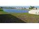 Backyard view with serene lake view, enclosed by a white fence at 16725 Delia St, Wimauma, FL 33598