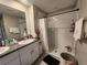 Bathroom featuring a walk-in shower, double sink vanity, and granite counters at 16725 Delia St, Wimauma, FL 33598