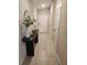Well-lit hallway with decorative table and tiled flooring at 16725 Delia St, Wimauma, FL 33598