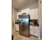 Modern kitchen featuring stainless steel refrigerator and white cabinets with granite countertops at 16725 Delia St, Wimauma, FL 33598