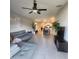 Open living area with tile floors, gray sofa, and view of dining and kitchen spaces at 16725 Delia St, Wimauma, FL 33598