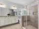 Bathroom featuring double sinks, granite countertops, a soaking tub and glass shower at 1767 Tonka Ter, Wesley Chapel, FL 33543