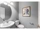 Half bathroom featuring a pedestal sink, round mirror and modern decorative accents at 1767 Tonka Ter, Wesley Chapel, FL 33543