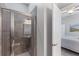 Bathroom featuring an open door to a bedroom and a tiled shower with glass door at 1767 Tonka Ter, Wesley Chapel, FL 33543