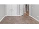 Bedroom features neutral carpet and base trim, with a view of the hallway at 1767 Tonka Ter, Wesley Chapel, FL 33543