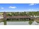 Community entrance over the water via unique wooden bridge with lush landscaping at 1767 Tonka Ter, Wesley Chapel, FL 33543