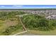 Aerial view of the serene walking path and bridge in the community surrounded by lush greenery and a pond at 1767 Tonka Ter, Wesley Chapel, FL 33543