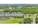 Aerial view of townhomes nestled around a pond and green golf course at 18148 Nassau Point Dr, Tampa, FL 33647