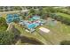 Aerial view of community swimming pool, tennis courts, playground, and recreation area with natural green beauty at 18967 Wood Sage Dr, Tampa, FL 33647