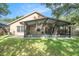 Spacious backyard featuring a covered patio with a fan, perfect for outdoor entertaining at 18967 Wood Sage Dr, Tampa, FL 33647