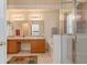 Bright bathroom featuring double vanity sinks, soaking tub, and glass-enclosed shower at 18967 Wood Sage Dr, Tampa, FL 33647