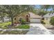 Charming single-Gathering home with a manicured lawn, mature trees, and an attached two-car garage at 18967 Wood Sage Dr, Tampa, FL 33647