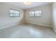 Bright, airy bedroom featuring neutral walls and flooring, illuminated by natural light from two windows at 1921 Ridgewood Dr, Clearwater, FL 33763