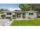 Charming single-story home with well-manicured lawn and garden pathway at 1921 Ridgewood Dr, Clearwater, FL 33763