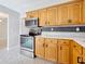 Kitchen with stainless steel oven/range, wooden cabinets, and black and white decorative backsplash at 1921 Ridgewood Dr, Clearwater, FL 33763