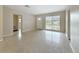 Sunny living room with terrazzo flooring, large window, and entry door at 1921 Ridgewood Dr, Clearwater, FL 33763
