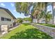 Spacious backyard with a retaining wall and a covered patio, offering a serene outdoor retreat at 1960 Sever Dr, Clearwater, FL 33764