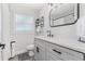 Bathroom featuring a gray single sink vanity with black hardware and a herringbone tile floor at 1960 Sever Dr, Clearwater, FL 33764