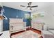 Charming Bedroom featuring a white crib, dresser, and a cozy area rug, bathed in natural light at 1960 Sever Dr, Clearwater, FL 33764