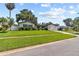 Well-manicured front yard showcasing a charming home with lush green lawn and mature trees at 1960 Sever Dr, Clearwater, FL 33764