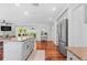 Bright, open kitchen with stainless steel appliances, granite countertops, and hardwood floors with island at 1960 Sever Dr, Clearwater, FL 33764