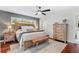 Spacious main bedroom with a dark accent wall, ceiling fan, wooden floors and a dresser at 1960 Sever Dr, Clearwater, FL 33764