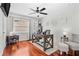 Hardwood floor office featuring a ceiling fan, neutral walls, and a large X-frame wooden desk at 1960 Sever Dr, Clearwater, FL 33764