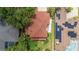Aerial view of a home with a red roof, solar panels, and a well-manicured backyard at 2015 Long Branch Ln, Clearwater, FL 33760
