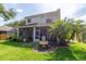 Charming backyard featuring a screened lanai, lush lawn, and a decorative water fountain at 2015 Long Branch Ln, Clearwater, FL 33760