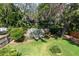 Spacious backyard featuring mature trees, lush lawn, and a wooden fence, offering a private outdoor space at 2015 Long Branch Ln, Clearwater, FL 33760