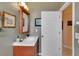Half bathroom with earth tone walls, wood vanity and framed mirror at 2015 Long Branch Ln, Clearwater, FL 33760