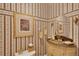 Ornate powder room featuring wallpaper, vanity and decor at 2015 Long Branch Ln, Clearwater, FL 33760