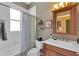 Cozy bathroom with shower/tub combo, wood vanity, mirror and earth tone walls at 2015 Long Branch Ln, Clearwater, FL 33760