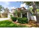 Charming exterior featuring a two-car garage, a lush green lawn, and mature trees creating a picturesque setting at 2015 Long Branch Ln, Clearwater, FL 33760