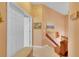 Upstairs hallway with neutral carpeting and wall decor, adjacent to a doorway and convenient linen storage at 2015 Long Branch Ln, Clearwater, FL 33760