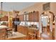 Open concept kitchen with dark wood cabinets and island, adjoining seating, and stainless refrigerator at 2015 Long Branch Ln, Clearwater, FL 33760