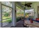 Screened-in lanai with brick flooring, ceiling fan, and comfortable seating perfect for outdoor relaxation at 2015 Long Branch Ln, Clearwater, FL 33760