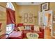 Comfortable living room featuring a plush red sofa, accent pillows, artwork, and ample natural light for a cozy retreat at 2015 Long Branch Ln, Clearwater, FL 33760