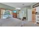 Bright main bedroom with balcony access, featuring a neutral palette and comfortable design and a large television at 2015 Long Branch Ln, Clearwater, FL 33760