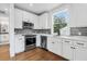 The well-designed kitchen features white cabinets, stainless steel appliances, and hardwood flooring at 2101 3Rd N Ave, St Petersburg, FL 33713