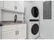 Bright laundry room features a stackable washer/dryer and granite countertops with built-in white cabinets at 2101 3Rd N Ave, St Petersburg, FL 33713