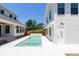 Backyard oasis featuring a sparkling swimming pool surrounded by tiled decking and pristine white houses at 2101 3Rd N Ave, St Petersburg, FL 33713